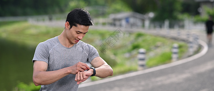 体育运动员在公园早上锻炼时 在智能观察上检查心率数据图片