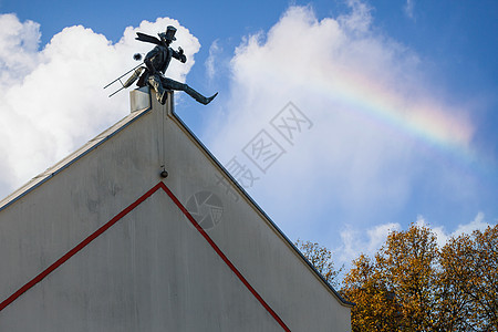 香尼清扫机坐在屋顶边缘休息 美丽的夏日天空和彩虹背景 笑声街道塑像地标雕塑烟囱纪念碑蓝色数字金属工作图片