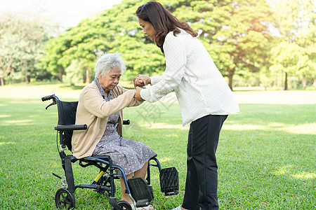 看护者帮助和照顾亚洲老年或老年老妇人病人坐在公园的轮椅上 快乐地坐在轮椅上 健康强大的医疗理念护理车轮机动性退休椅子女儿母亲药品图片