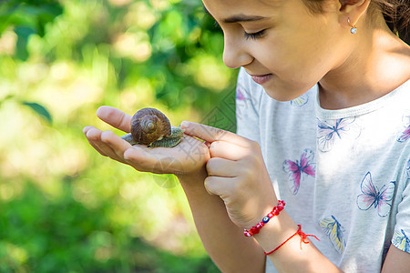 孩子检查了树上的蜗牛 有选择地集中注意力冒险生物学动物教育男生植物学童年花园镜片玻璃图片