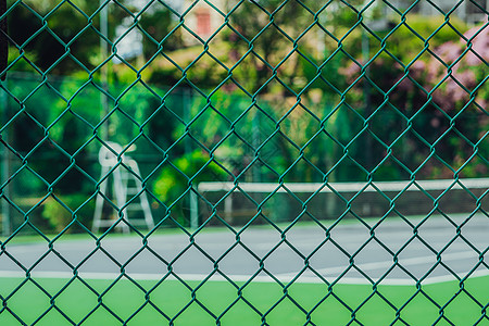 现代时尚酒店空荡荡的网球场 裁判塔 透过金属网围栏观看 明亮清新的热带绿色 体育乐趣暑假生活方式活动户外晴天图片