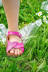 一个小女孩的腿 踩一个塑料瓶子食物服务生态垃圾袋女士地球回收全球材料旅行图片