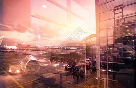 从机场大楼的玻璃窗向外看 夜间停靠在机场的客机 商业飞机和服务卡车在机场 空运 跑道交通图片