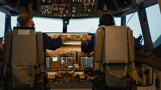 飞机船长和女性副驾驶员在仪表板上确定高度图片