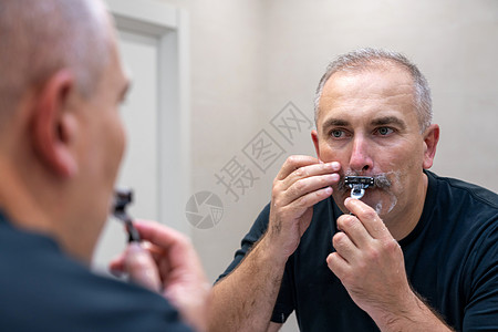 早上洗手间用泡沫擦刮剃刀的人护理男性胡须中年成人隔断凝胶奶油浴室刮胡子图片
