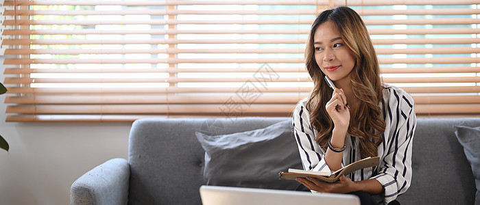 有吸引力的千百年女性在读书的同时 在家里沙发上放松图片