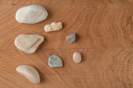 各种大小的平滑石块散落在木板上图片