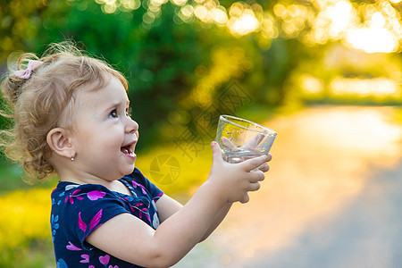 小孩喝杯水 有选择的专注孩子们女孩幸福标签居住玻璃婴儿食物瓶子情感图片