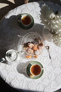 英语风格的茶间休息 在清晨阳光下用鲜花和甜甜圈维持生命羊角仪式小麦装饰食物面包咖啡餐具桌子美食图片