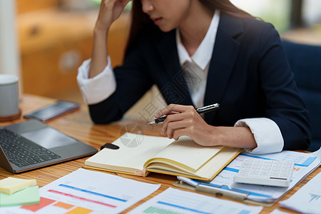 亚洲女商务人士在与客户交谈时担心今年的营销计划职场破产思维工人文档文书笔记本员工工作危机图片