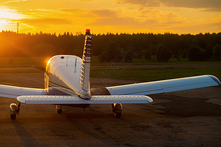 四轮式飞机停在私人机场 看到日落背景有螺旋桨的飞机后视线尾巴运输旅行天气吹笛者自由航班航空轮子齿轮图片
