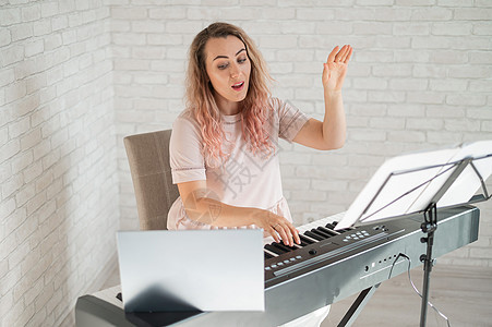 远程音乐课 歌唱老师在笔记本电脑摄像头上记录钢琴播送音乐家博客视频导师歌曲女孩工作教训背景图片