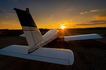 一架私人飞机在黄昏降落时的休眠钟后 停靠在日落背景上的一小架飞机近视机身旅行乘客喷射全景树木森林螺旋桨速度航空图片