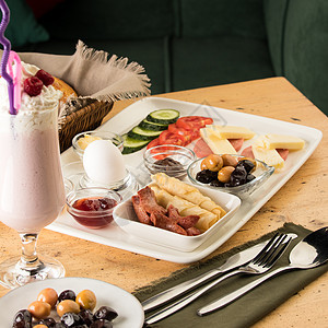 一张白色早餐盘子和木桌上一杯冰淇淋的近镜头图片