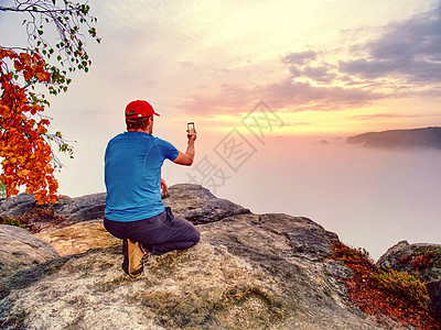 男性旅行者使用电话共享秋山风景社会自拍日落动机山脉爬坡观光成功顶峰数据图片