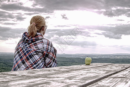 年轻金发金发女孩在木桌休息闲暇旅行背包背心环境运动装女性远足者桌子旅游图片