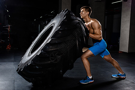 在健身房训练男子翻轮胎运动员举重重量运动健美采摘奉献精神男性耐力图片