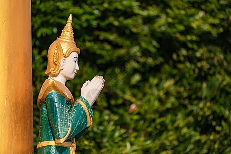 在缅甸的自然背景下 在寺庙里用双手折叠着的佛像祈祷背景图片