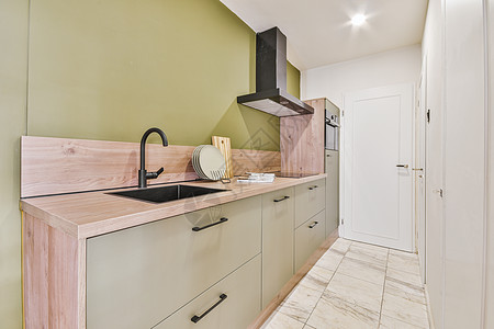带绿色家具的现代厨房内内部龙头装设白色组织建筑学架子住宅公寓家庭柜台图片