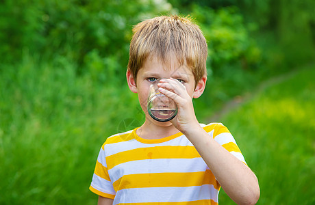 男孩儿喝杯水 有选择的焦点场地横幅男性公园饮料青年手臂玻璃童年保湿图片