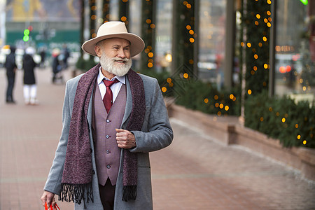 长胡子的祖父在街上走着商业街道阳光帽子管理人员胡须夹克城市成人假期图片