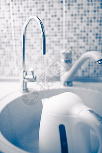 在过滤水龙头下用清净的淡水浇灌的水壶茶壶蓝色力量调色咖啡器具厨房饮料背景图片