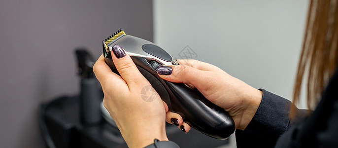 女性手中的头发剪裁机刀刃剃刀技术理发工具配饰职业修剪理发师器具图片