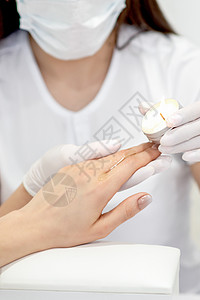 在指甲上涂蜡的修工芳香成人治疗师按摩师蜡烛抛光沙龙卫生棕榈保健图片