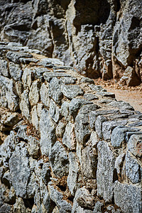 岩石悬崖旁边的石墙和徒步之路图片