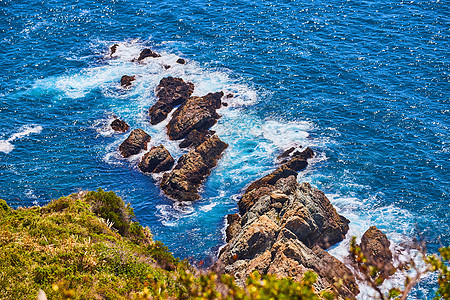 从悬崖向下看海洋 满是巨石和海浪崩塌图片
