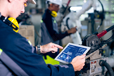 工厂工人在一个车间中使用精密机器人臂工作制造业商业药片自动化工程师机械臂传感器创新数据网络图片