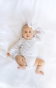 新生婴儿躺在白床上 有选择地集中注意力生长身体女性毯子女孩横幅孩子几个月尿布乐趣图片
