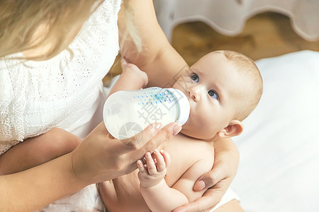 妈妈用瓶子喂婴儿 有选择的焦点牛奶奶瓶女士后代父母家庭女性儿子投标女孩图片