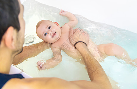 父亲给小宝宝洗澡 有选择地集中注意力孩子卫生女孩身体浴室保健父母生活女儿喜悦图片
