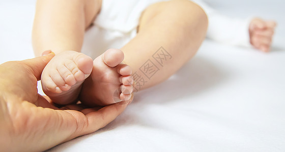 妈妈抱着宝宝的腿 有选择地集中精神手指新生童年母亲压痛父母父亲横幅女孩皮肤图片