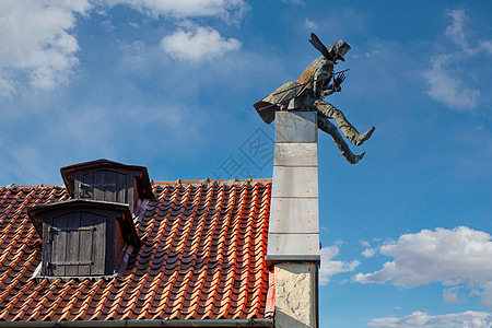 立陶宛Klaipeda烟囱扫荡纪念碑 红砖屋顶和蓝天空 背景有白云图片