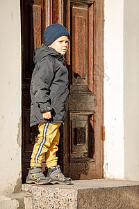秋天在克莱佩达老城中心古老的门前 一个可爱的男孩图片
