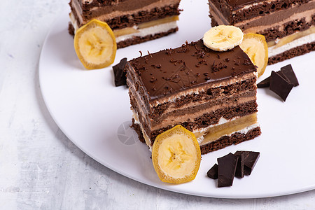 在白色盘子上 提供美味巧克力蛋糕片的美餐蛋糕奶油美食甜点香蕉小吃水果糕点食物营养图片