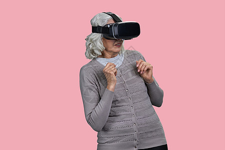 用虚拟眼镜站在彩色背景上 惊恐的老年女性 (笑声)图片