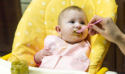 妈妈给婴儿喂蔬菜 有选择的焦点儿子椅子童年早餐父母快乐生长午餐勺子女孩图片