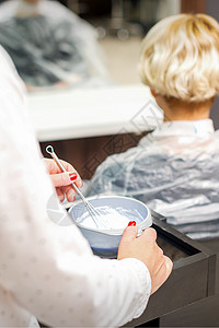 理发师正在集装箱内准备染色剂染料护理塑料头发画笔治疗女性金发美容化妆品图片