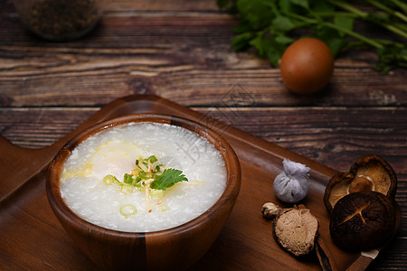 大米粥 有软煮蛋 切姜和木碗中的 冷冻是许多亚洲国家流行的稻米粥种菜 但是图片
