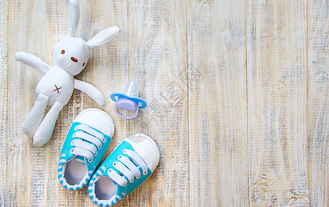 婴儿衣物和附件在浅薄背景上 有选择的焦点连体衣配件桌子衣服帽子袜子童年蓝色生日母性图片