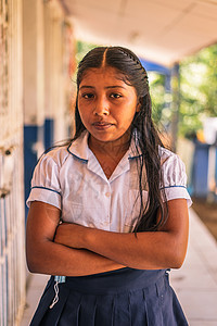 一位尼加拉瓜小学生女孩在马萨亚笑着看着摄影机的双臂穿过脸部 照片垂直照像图片