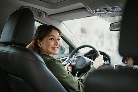 亚裔女性驾驶汽车 欢笑的笑容与喜悦在旅行途中正面表达的表态图片