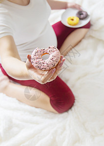 孕妇吃甜甜甜圈 有选择性的焦点母亲腹部身体女性饮食母性甜甜圈早餐垃圾肚子图片