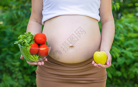 孕妇手里拿着蔬菜 有选择的专注点怀孕女士腹部母性肚子食物横幅幸福家庭福利图片