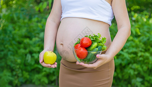 孕妇手里拿着蔬菜 有选择的专注点横幅成人生活厨房女士母亲腹部福利营养女孩图片