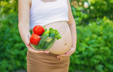 孕妇手里拿着蔬菜 有选择的专注点肚子沙拉家庭厨房福利营养父母女性生活横幅图片