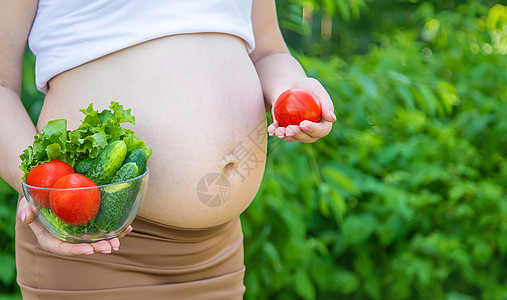 孕妇手里拿着蔬菜 有选择的专注点食物父母肚子怀孕横幅身体成人厨房营养女性图片
